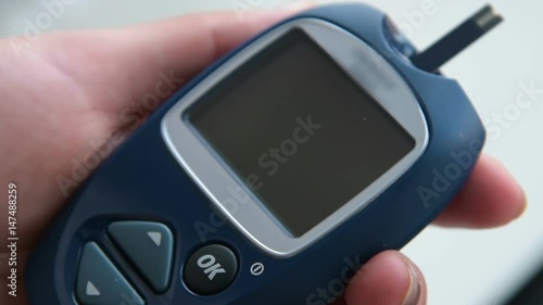 Close-up shot of inserting blood test strip into the glucometer. It is ready to measure sugar level