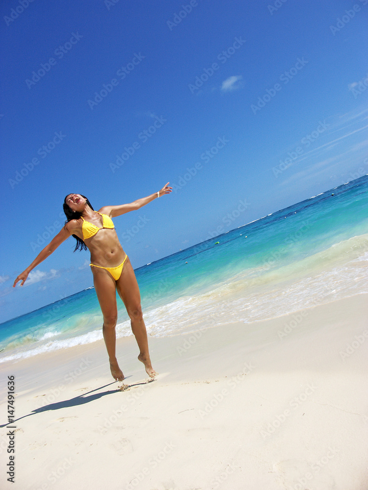Mujer latina corriendo y saltando en la playa. foto de Stock