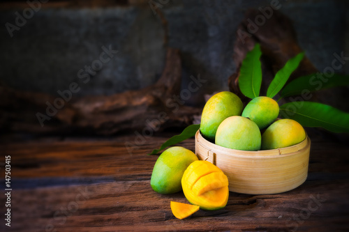 mango and mango slices on a wooden table