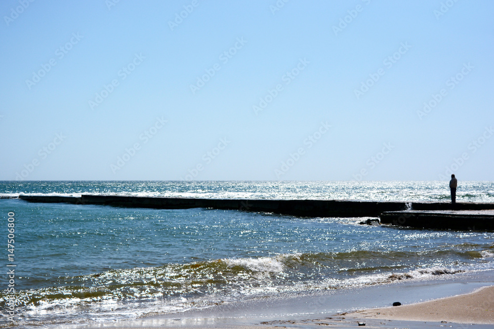 Beautiful landscape of a black sea beach with a breakwater.
