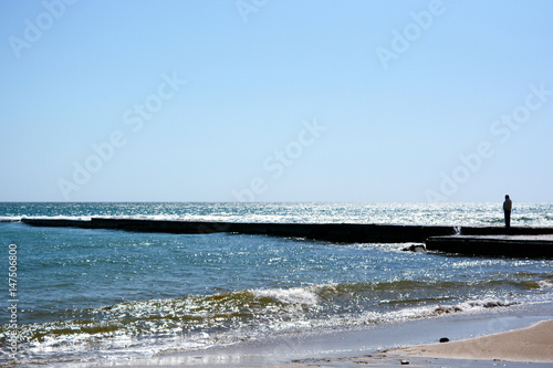 Beautiful landscape of a black sea beach with a breakwater.