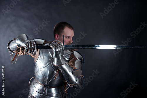 A medieval warrior with a sword. Knight on dark background