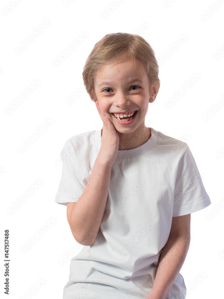 Portrait of a little girl with blond hair and a white T-shirt that laughs and holds with one hand for her cheek on a white background Portrait of a little girl with blond hair and a white T-shirt that laughs and holds with one hand for her cheek on a white background