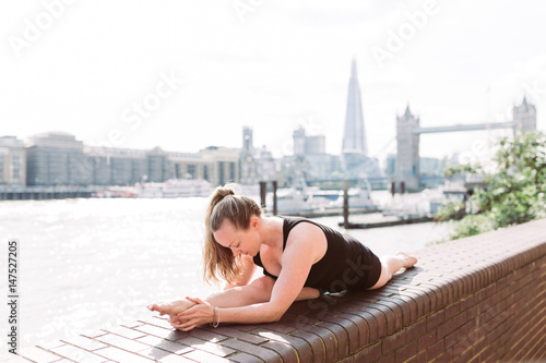 Woman in yoga position in fron of Tower Bridge, London © Nena