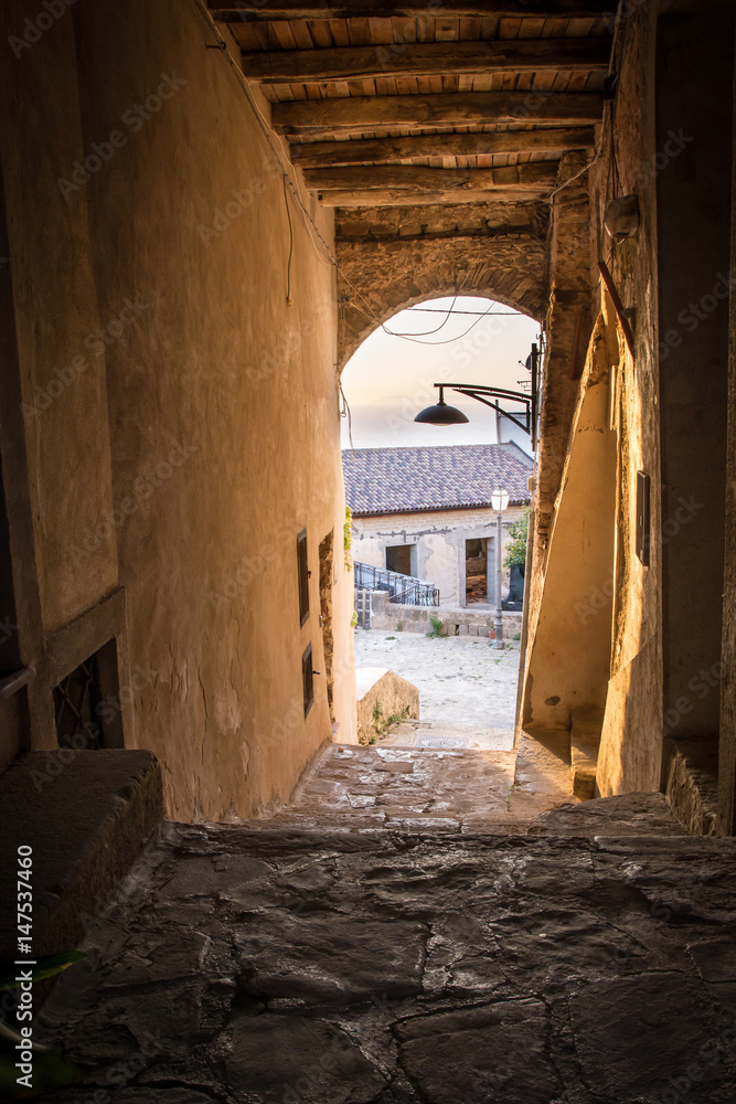 Fototapeta premium Pictureque view of a little street of Castellabate, ancient town in Cilento (Italy) at sunset.