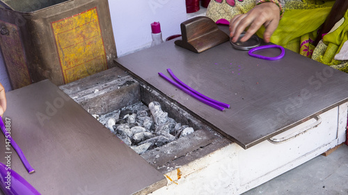 Indian Man Making cheap plastic bracelets near Samode Palace. photo