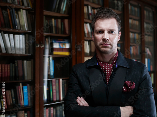 Man in suit standing in library