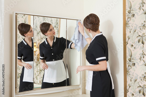 room maid cleaning mirror