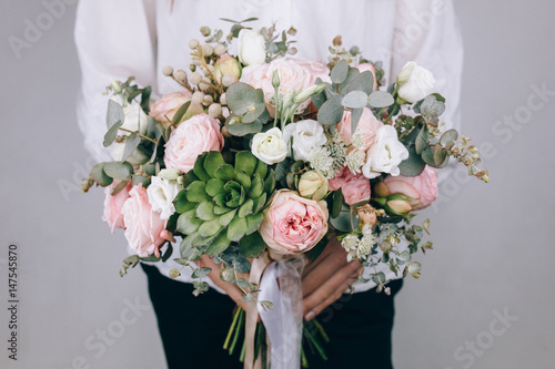 Florist at work. Make rich bouquet diferent color and flowers. Bunch in their hands photo