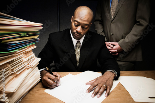 Man doing paperwork with man behind him photo