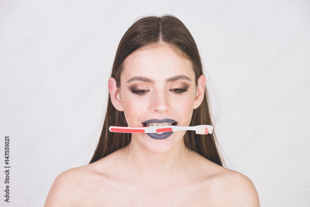 girl with teeth braces and brush, has fashionable makeup girl with teeth braces and brush, has fashionable makeup
