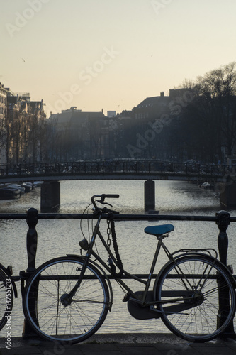 One bike near the canal in Amsterdam in the evening in the dusk