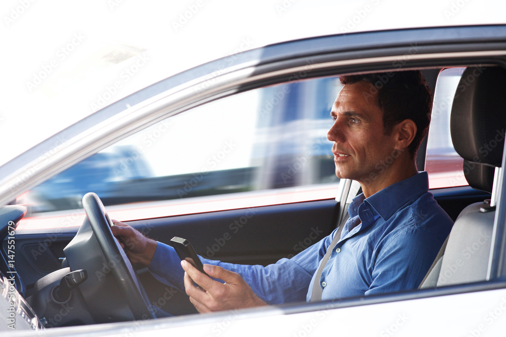 man holding mobile phone and driving