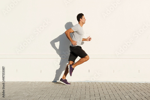 middle age man running by white wall