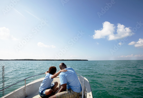 Father and son looking at view from motorboat