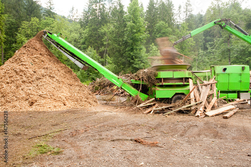 Pile of wood chippings and green truck photo