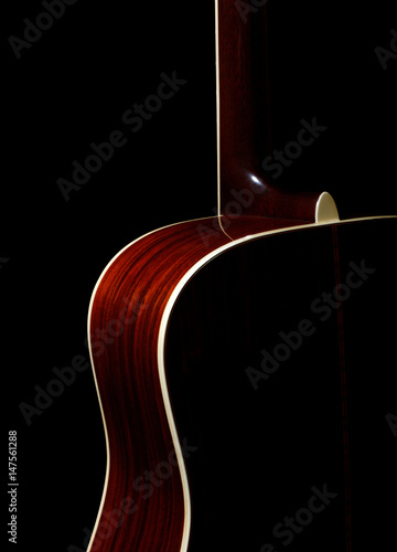 Acoustic guitar against black background