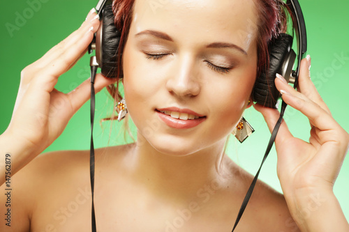 Young happy woman listening to music with headhones photo