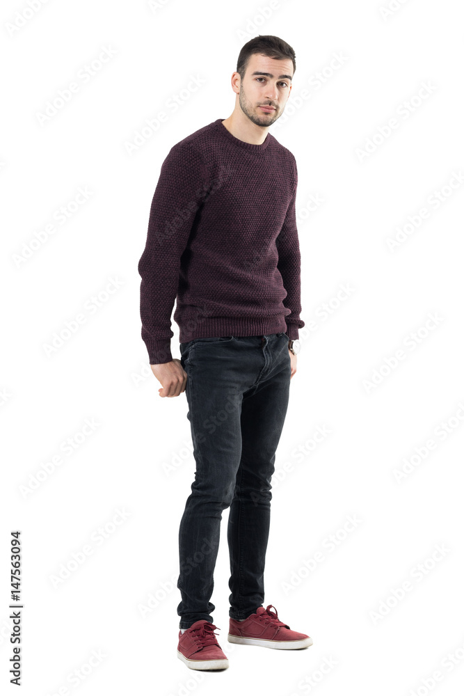 Cool seductive young casual man with hands in back pockets looking at camera. Full body length portrait isolated over white studio background. Cool seductive young casual man with hands in back pockets looking at camera. Full body length portrait isolated over white studio background.