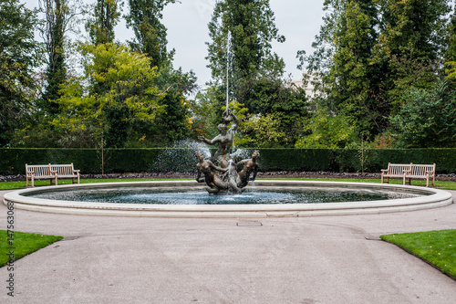 Obraz na płótnie Fountain in London Park, squirting water all the way with benches on sides w salonie