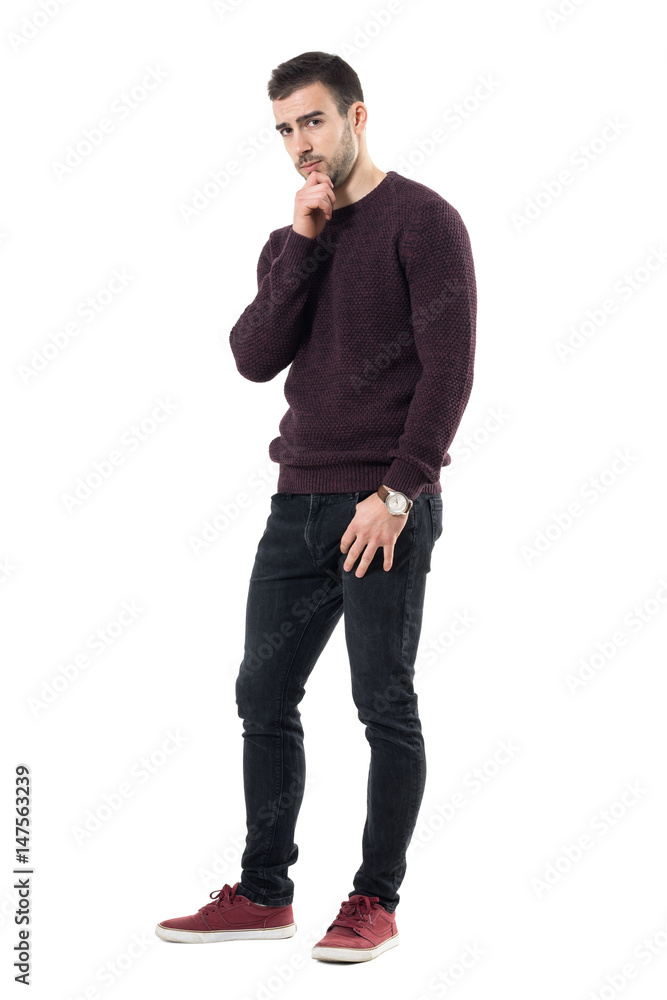 Skeptical suspicious man with hands on chin looking at camera distrustful. Full body length portrait isolated over white studio background. Skeptical suspicious man with hands on chin looking at camera distrustful. Full body length portrait isolated over white studio background.