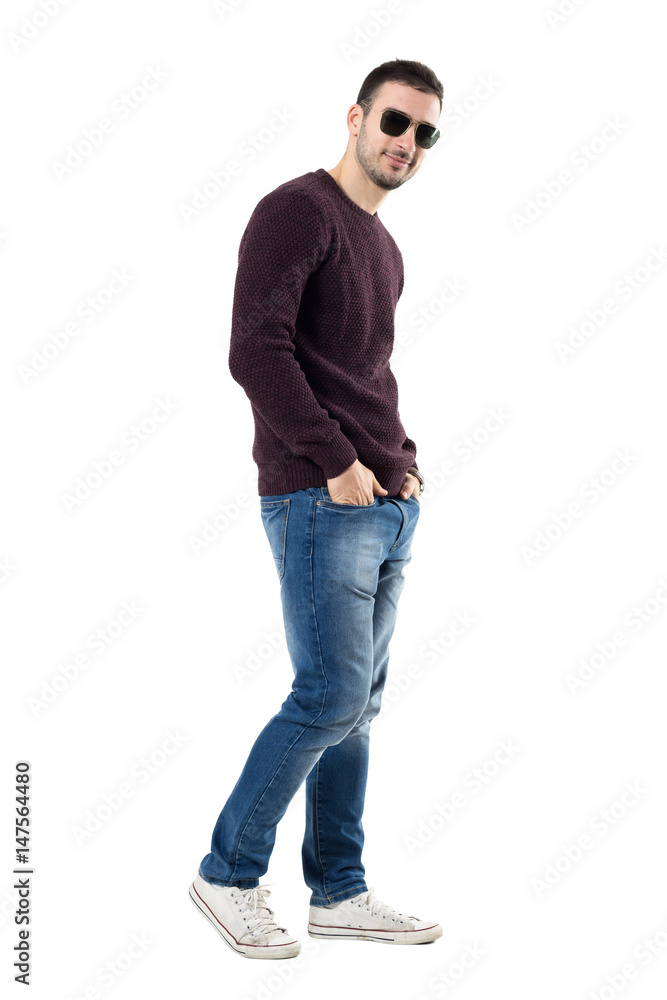 Confident young seductive man with sunglasses smiling at camera. Full body length portrait isolated over white studio background. Confident young seductive man with sunglasses smiling at camera. Full body length portrait isolated over white studio background.