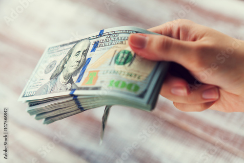 Many dollars falling on woman's hand with money