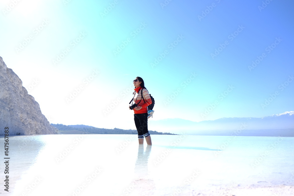 Happy woman take photo standing in the water. the tourist at Pamukkale, Turkey