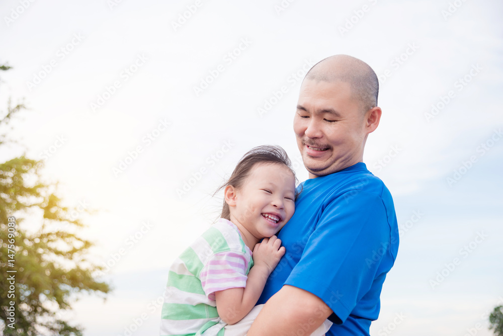 Asian father holding his daughter in park Asian father holding his daughter in park