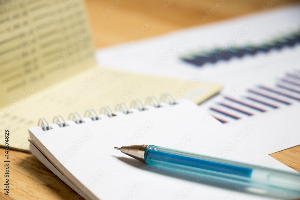 Background of passbook, note book with pen and financial graph Background of passbook, note book with pen and financial graph