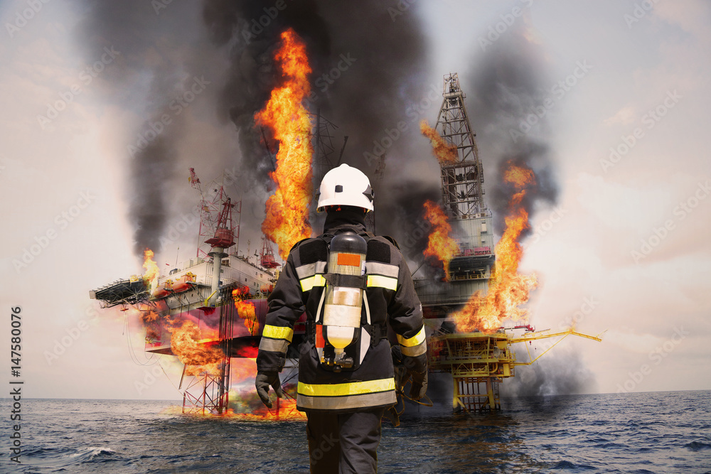 Fototapeta premium Firefighter in oil and gas industry with mission successful for protect with emergency case or worst case, Personal protective equipment of firefighter team and teamwork for danger mission.