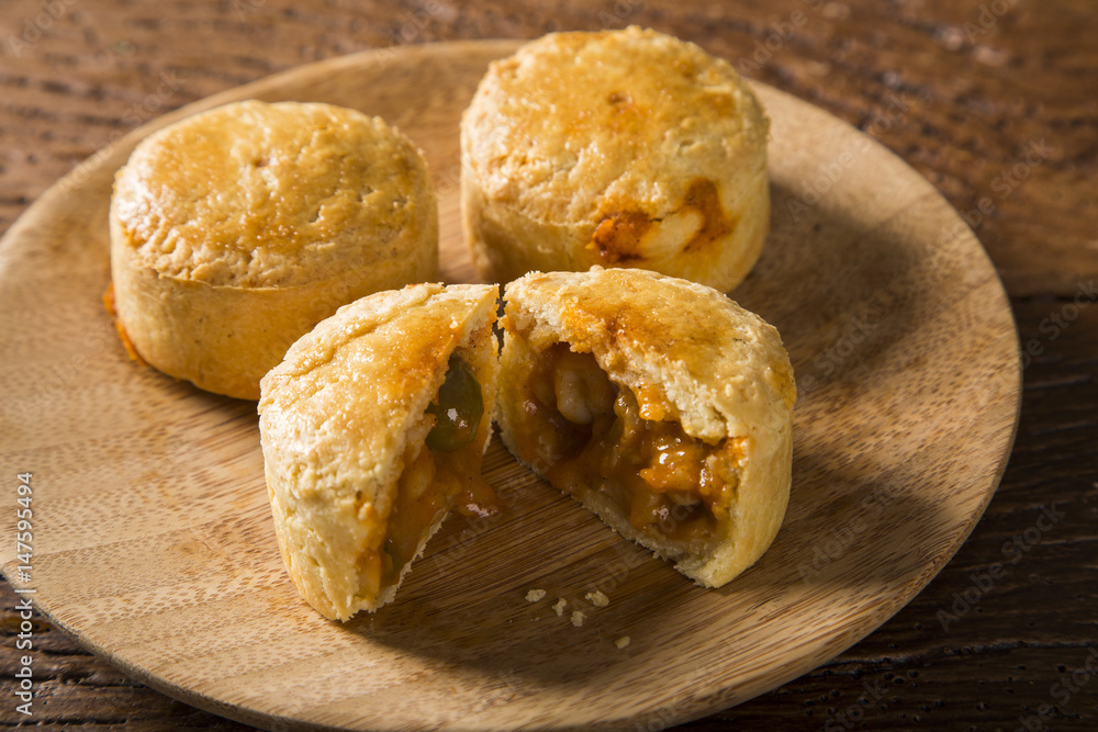 Empada Brazilian snack. pie with shrimp on wood plate on wooden background Empada Brazilian snack. pie with shrimp on wood plate on wooden background