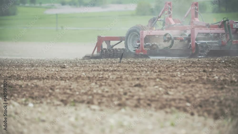 Agricultural tractor cultivating field. Agricultural tractor cultivating field.