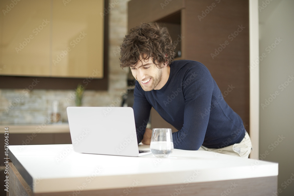 Home office. Shot of a confident young man using laptop while working from home. Home office. Shot of a confident young man using laptop while working from home.