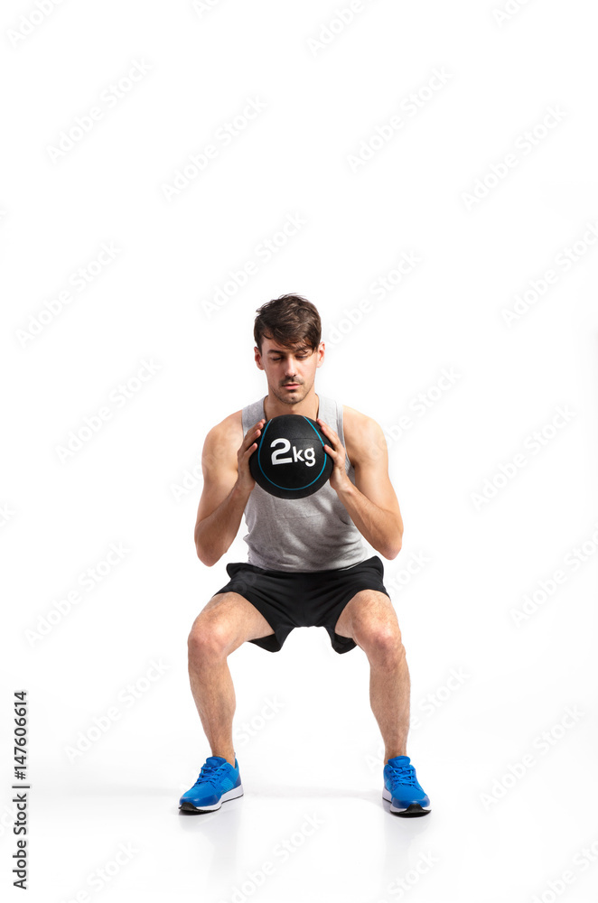 Handsome fitness man holding medicine ball, studio shot. Handsome fitness man holding medicine ball, studio shot.