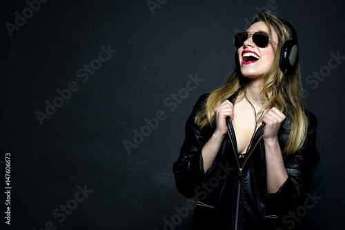 Smiling young blonde girl listening music