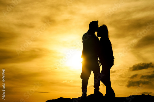 romantic time of sillhoutte of lover kissing during sunset