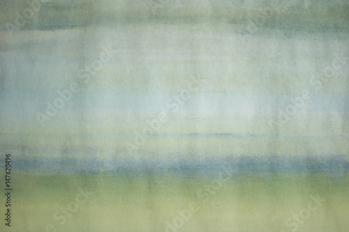 Close-up photo of a hand painted, light blue and green abstract painting. Simple image of an empty, minimalist, monochromatic background.