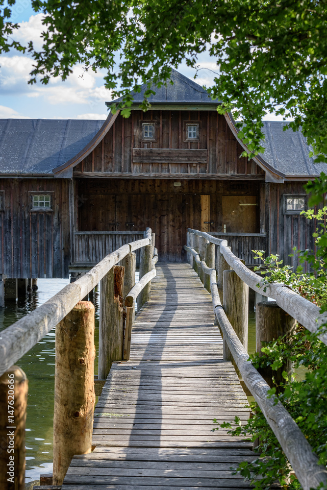 Footbridge leading to old wooden boats house on German lake Footbridge leading to old wooden boats house on German lake