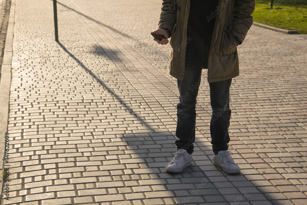 Portrait of handsome young man using his mobile phone in the street. Portrait of handsome young man using his mobile phone in the street.
