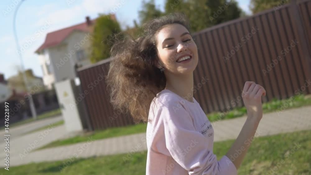 Cute young girl skateboarder goes along the road with her skateboard Cute young girl skateboarder goes along the road with her skateboard