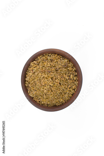 Freekeh in a wood bowl in white background seen from above