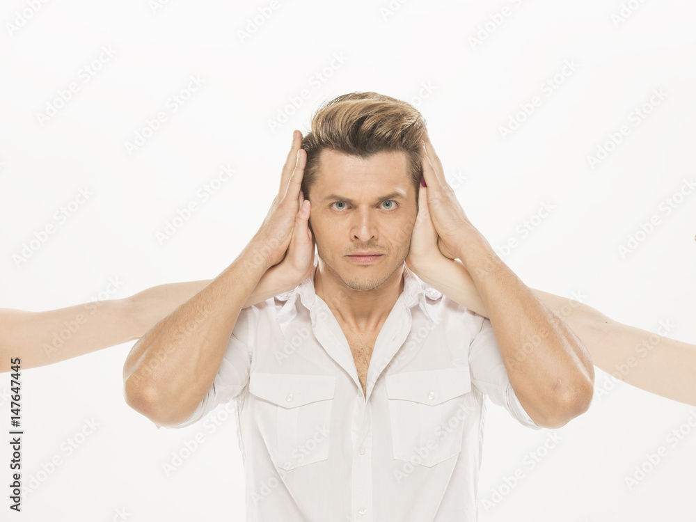 Man with arms crossed on his chest, closed mouth and ears by womans hands, isolated on white Man with arms crossed on his chest, closed mouth and ears by womans hands, isolated on white