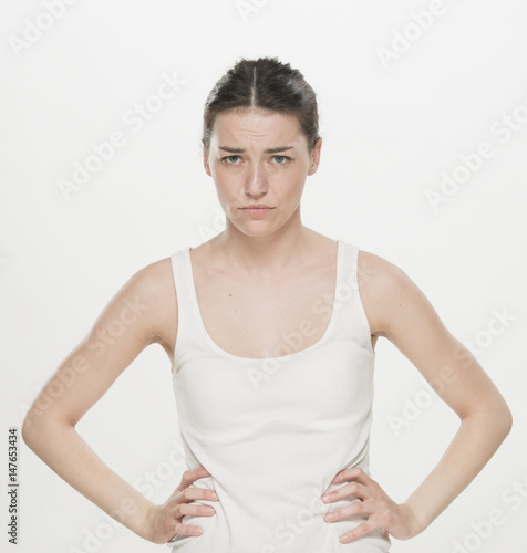 Portrait of a beautiful young women, dressed white T-shirt , skeptical expression, isolated on white © serhii