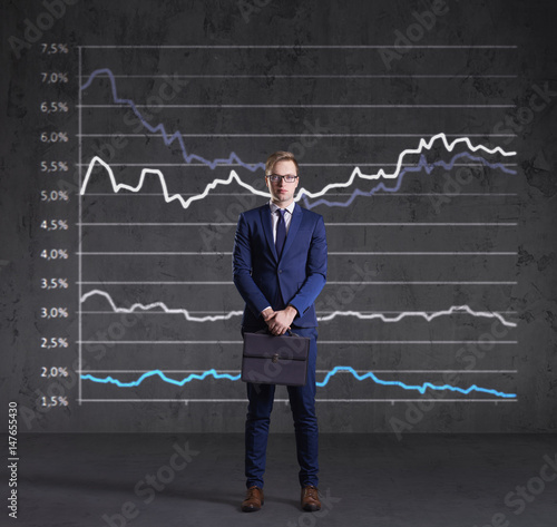 Businessman with briefcase standing on a diagram background. Business, finance, investment concept.