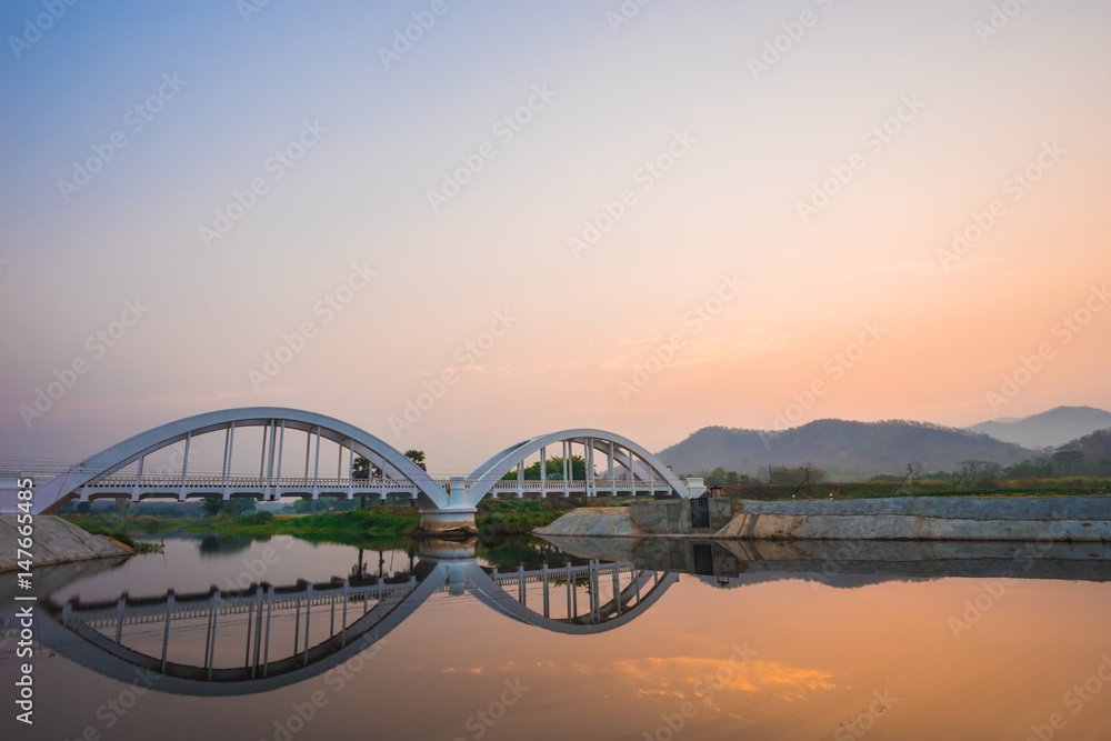 Naklejka premium White bridge backdrop orange sky at mae tha, Lamphun, Thailand. 