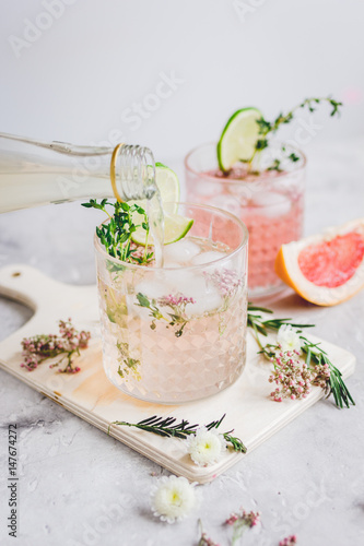 natural nonalcoholic cocktail with herbs and cut lime on stone desk background