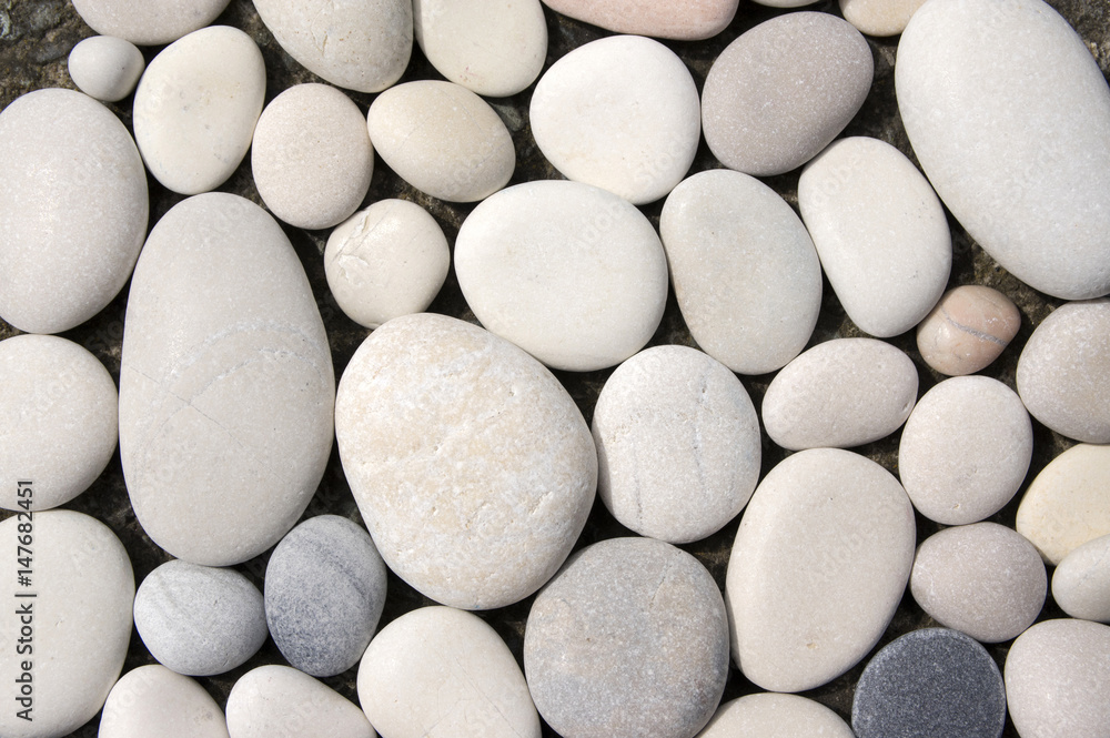 Group of light pebbles in one layer, simple stones background Group of light pebbles in one layer, simple stones background