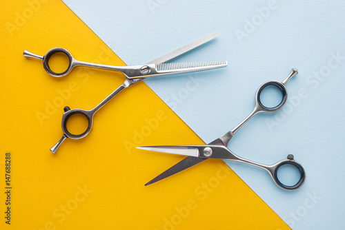 Obraz na plátně Two sets of stainless steel hairdressing scissors arranged horizontally and para