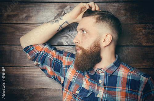 Bearded man posing on woode...